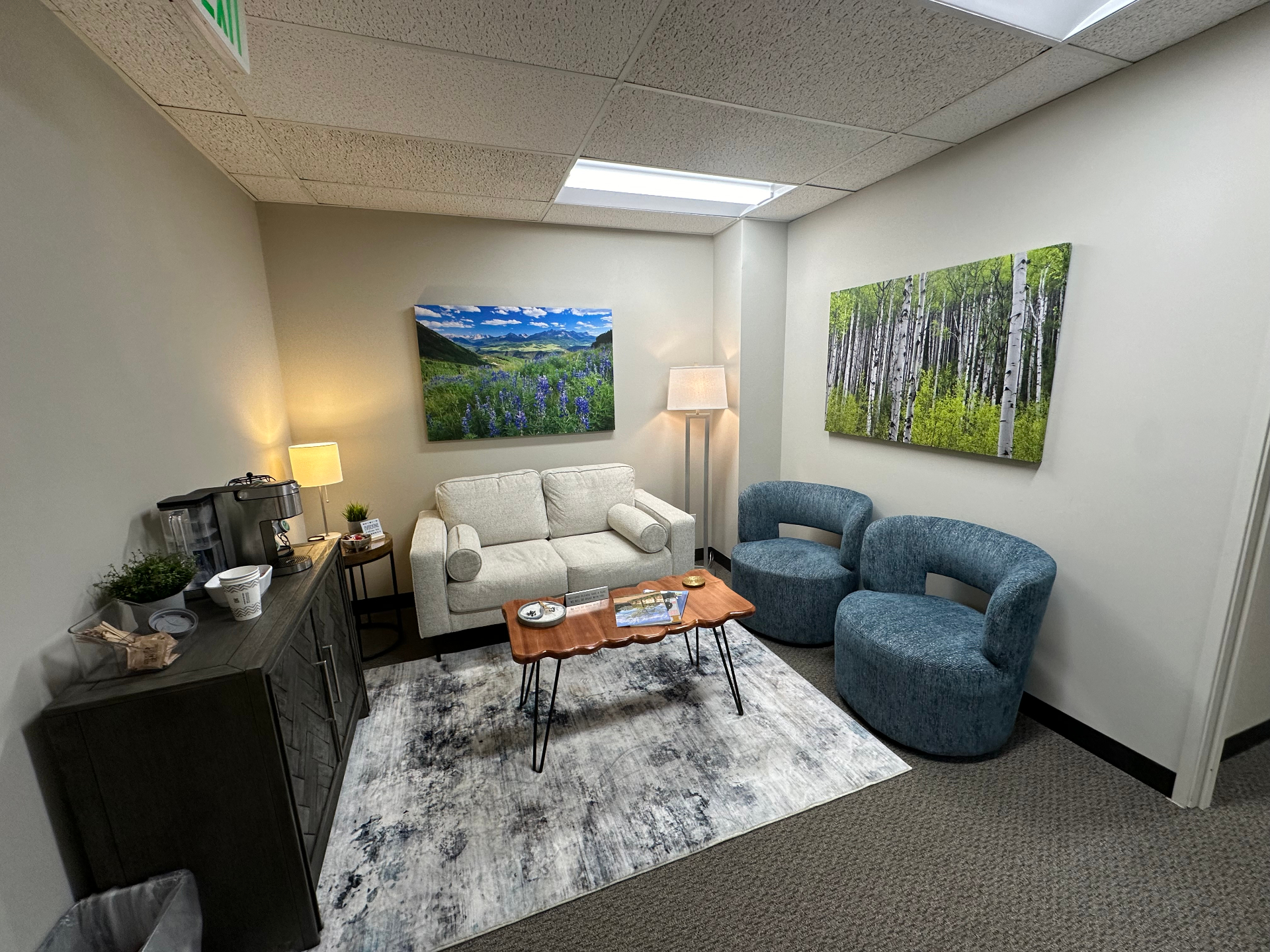 Inner Calm Counseling waiting area with soft seating, lamps, and Colorado landscape art.